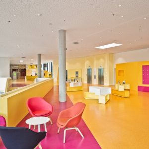 Lounge Bereich in einer Bibliothek mit farbenfrohem Interior und einer dezenten und doch effizienten Beleuchtung